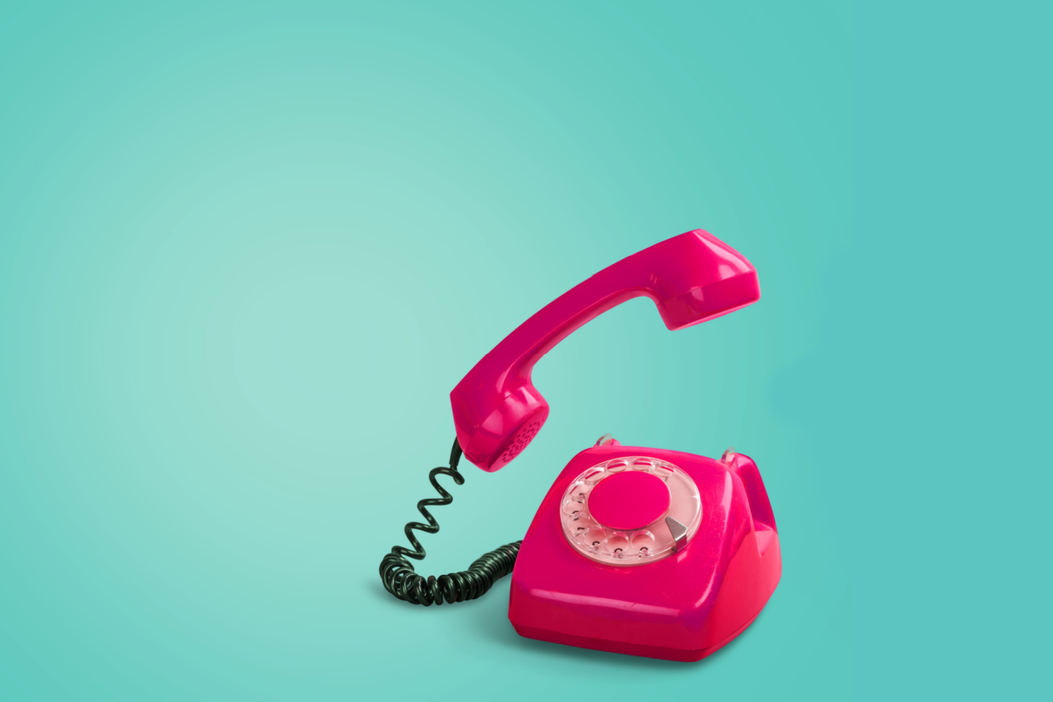 Vintage pink phone on a turquoise background with the receiver lifted